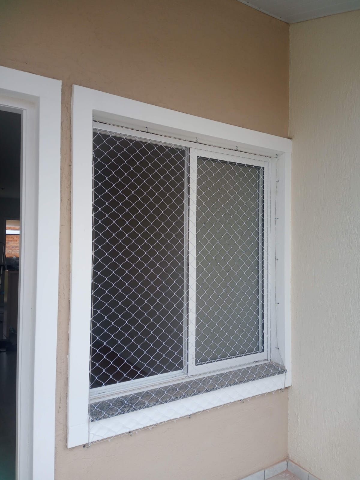 Rede branca instalada em janela de apartamento