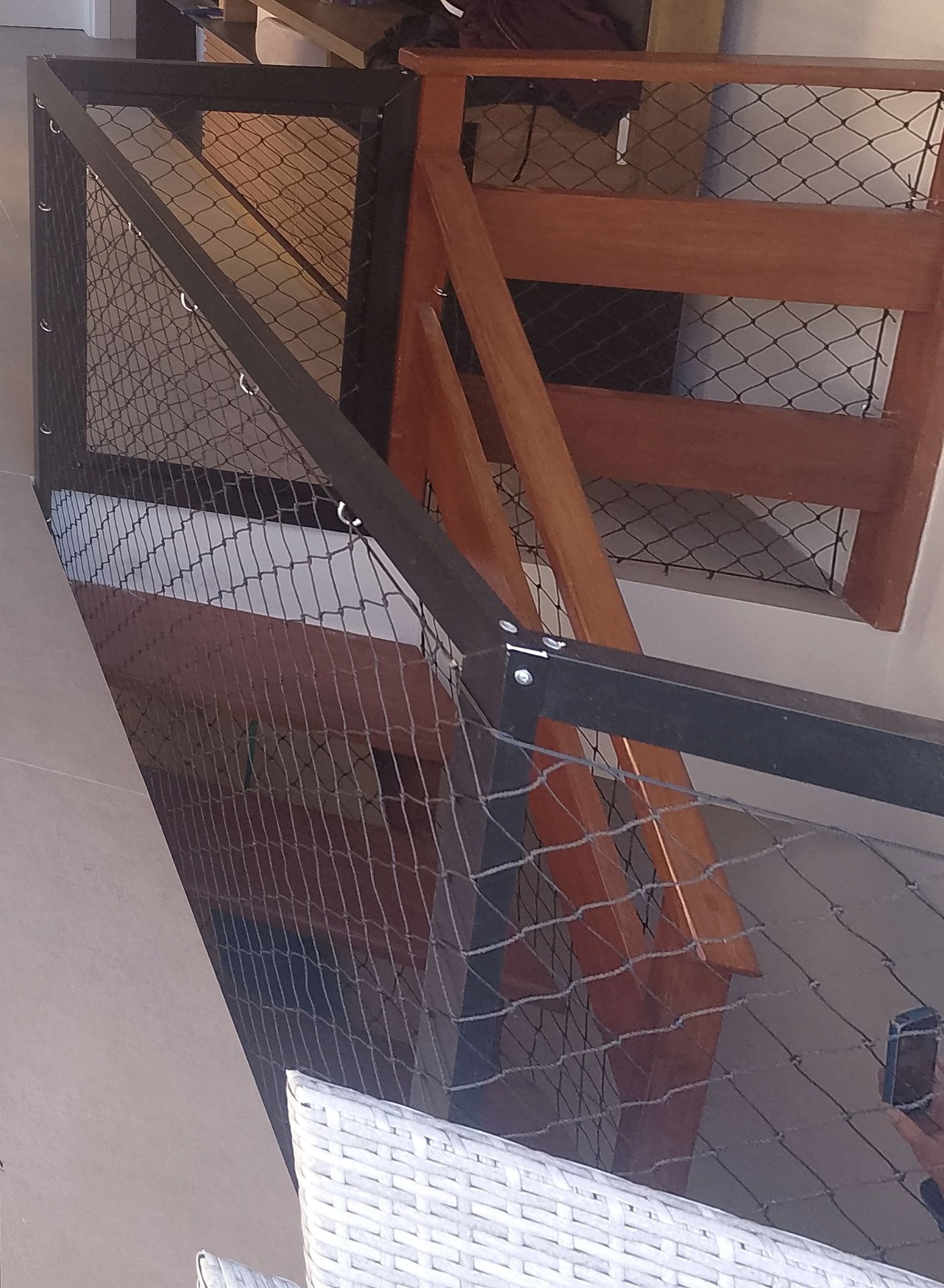 Mezanino com guarda-corpo de madeira e rede de proteção preta