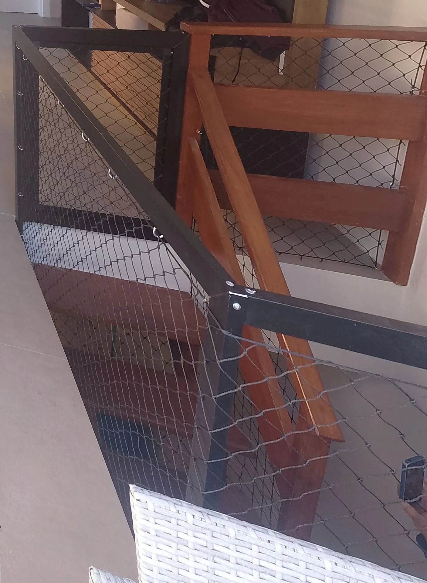 Mezanino com guarda-corpo de madeira e rede de proteção preta