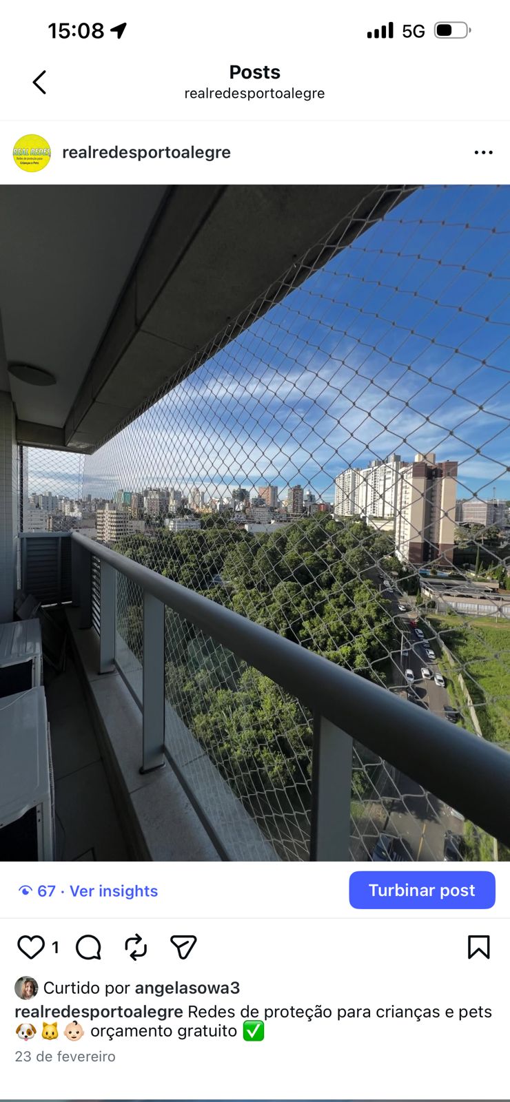 Sacada de prédio com rede de proteção e vista ampla da cidade