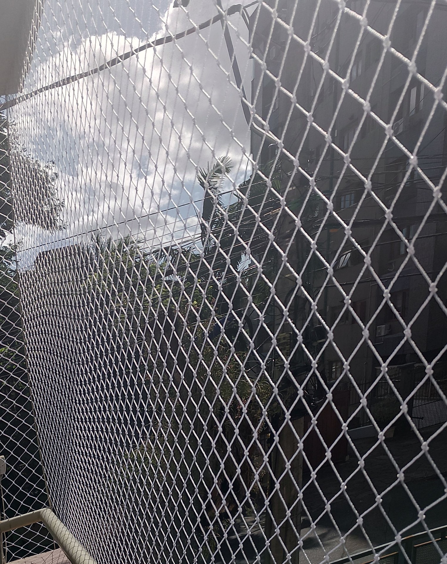 Sacada com rede de proteção branca em apartamento residencial