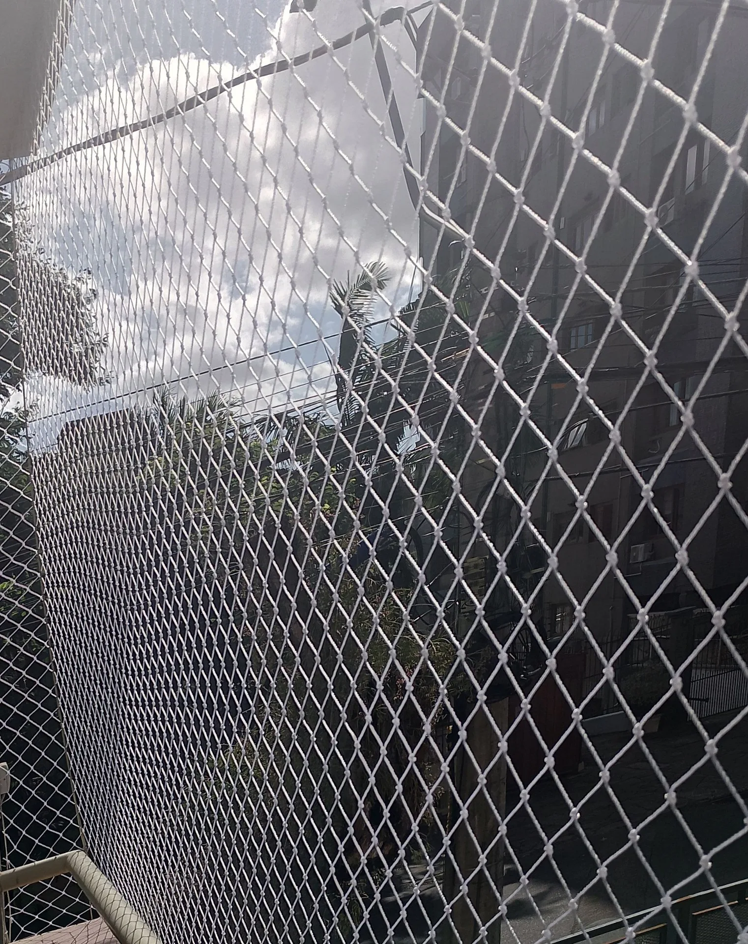Sacada com rede de proteção branca em apartamento residencial