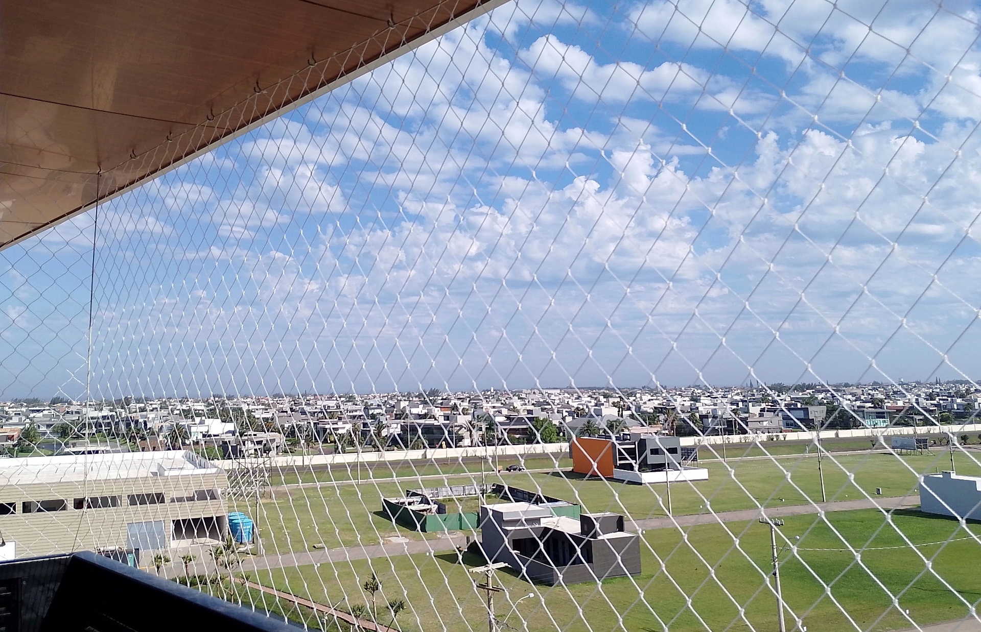 Sacada de cobertura com rede branca e vista para condomínio